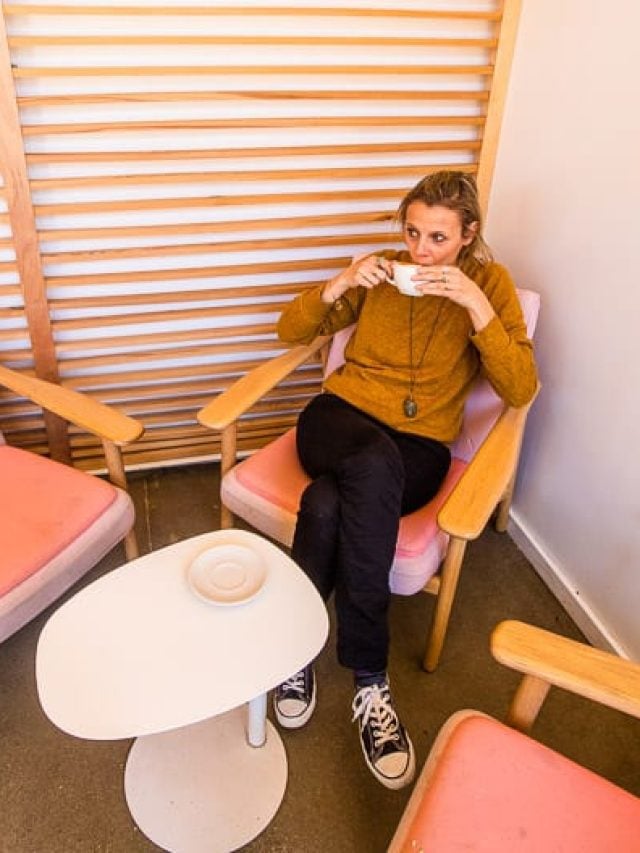 Woman sitting on a chair sipping coffee.