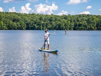a man stand up paddle boarding on a lake