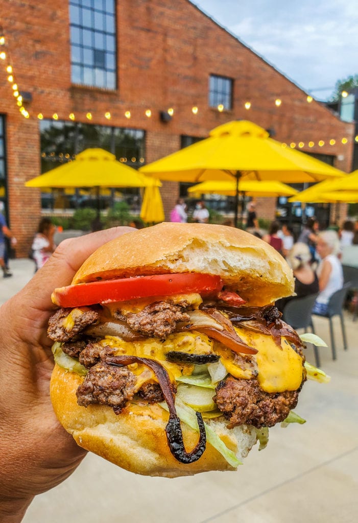 Hand holding up a hamburger