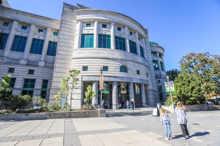 A person walking down a street in front of a building