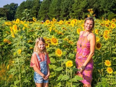 Mother and daughter taking pictures at the sunflower field.