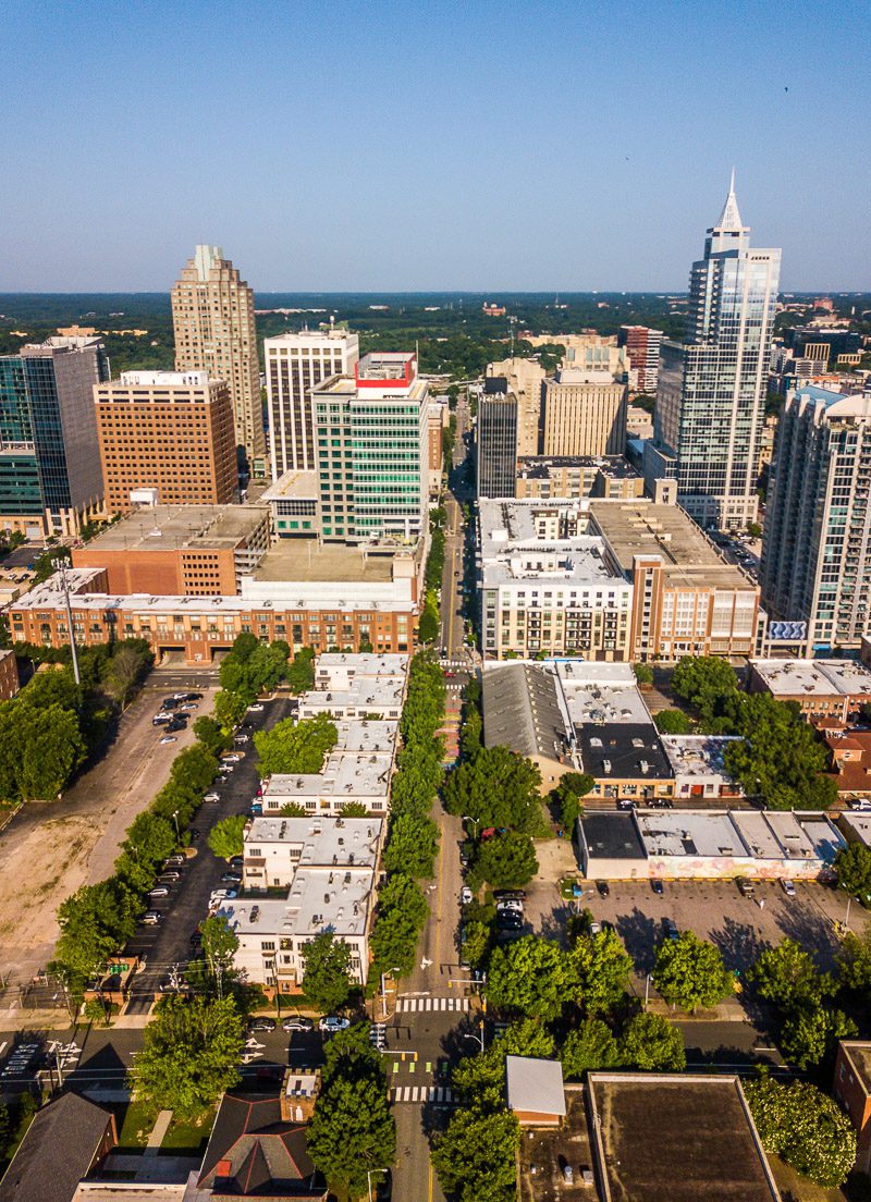 Aerial view of a city skyline and the houses, streets and trees in downtown Raleigh