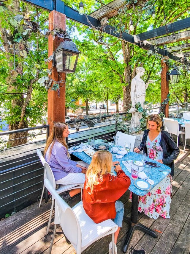 A woman and children sitting at table on outdoor patio