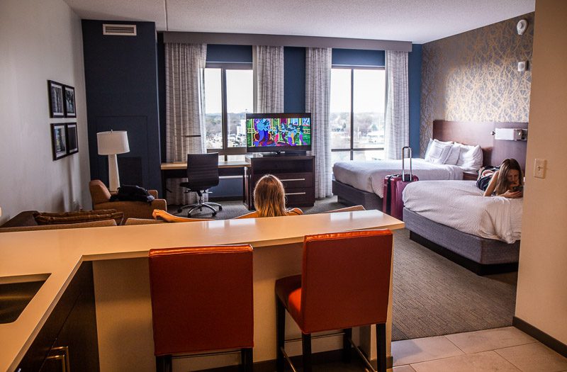 a hotel room with a woman watching tv