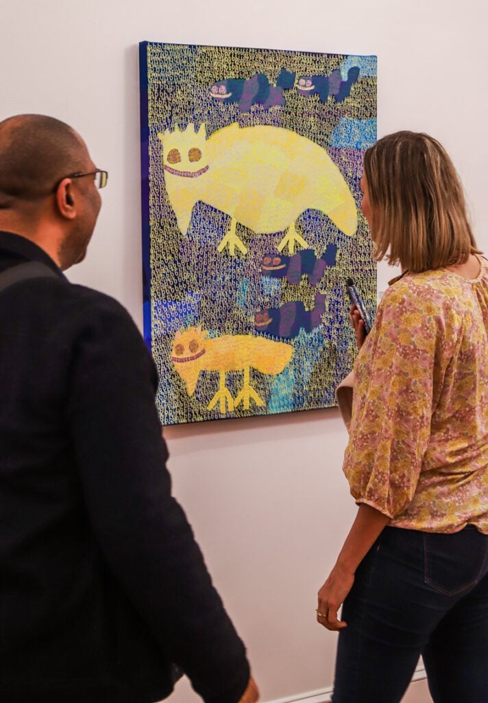 A man and a woman looking at a painting