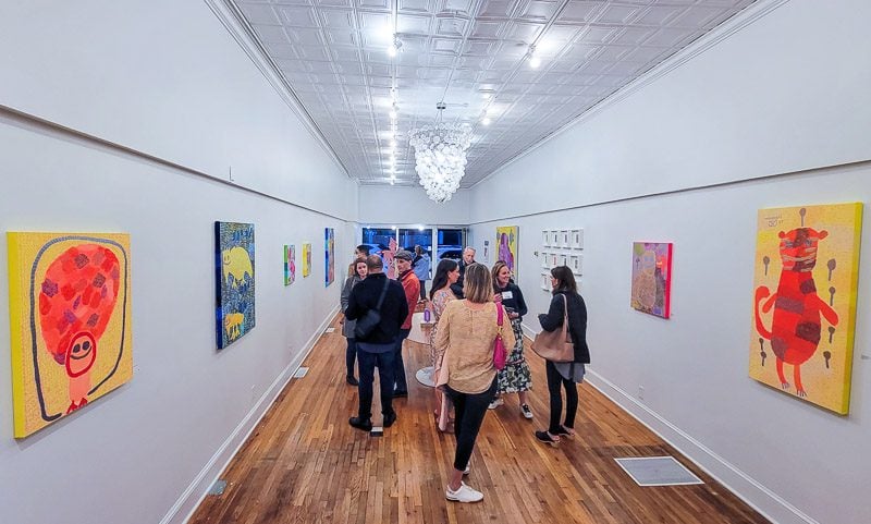 A group of people standing in an art gallery