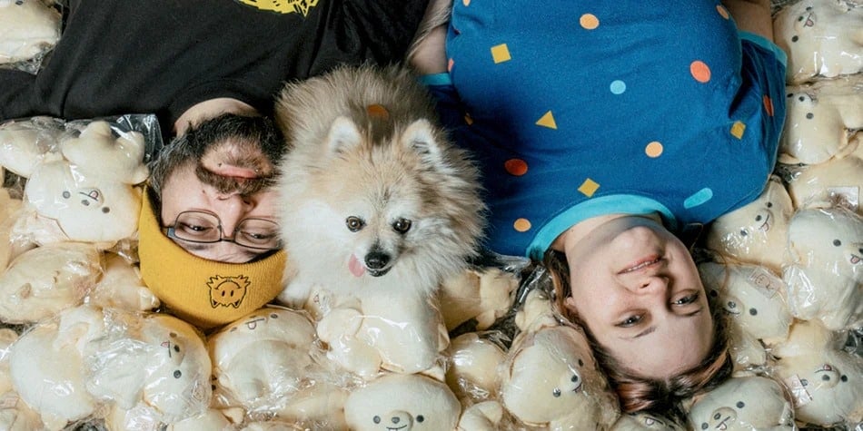 two people laying in stuffed dogs with a real dog