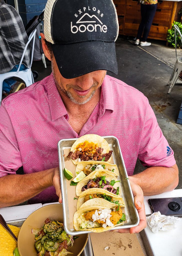 A person sitting at a table with a plate of tacos