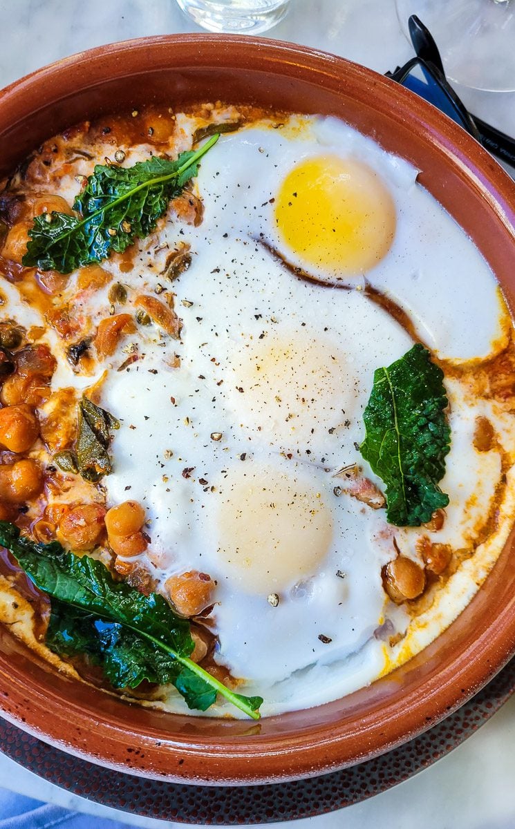A bowl of food on a plate shakshuka with egg Rosewater Kitchen North Hills