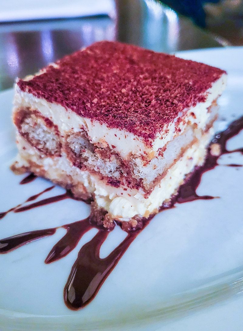 A piece of red cake on a plate Cream