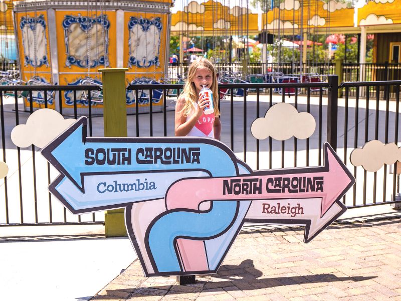 Gilr in front of direction sign at Carowinds Amusement Park