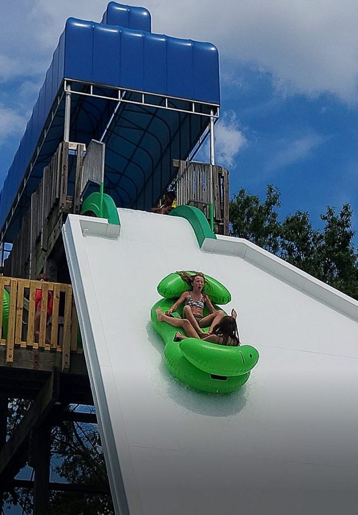 Green two person float going down The Edge Waterslide at Wet\'n Wild