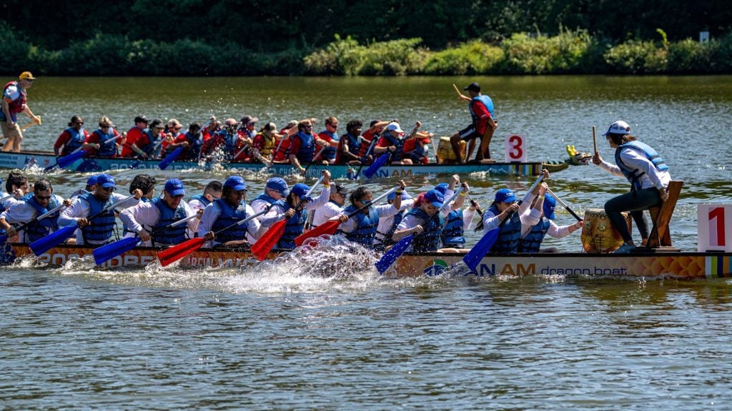 People racing dragon boats on the water 