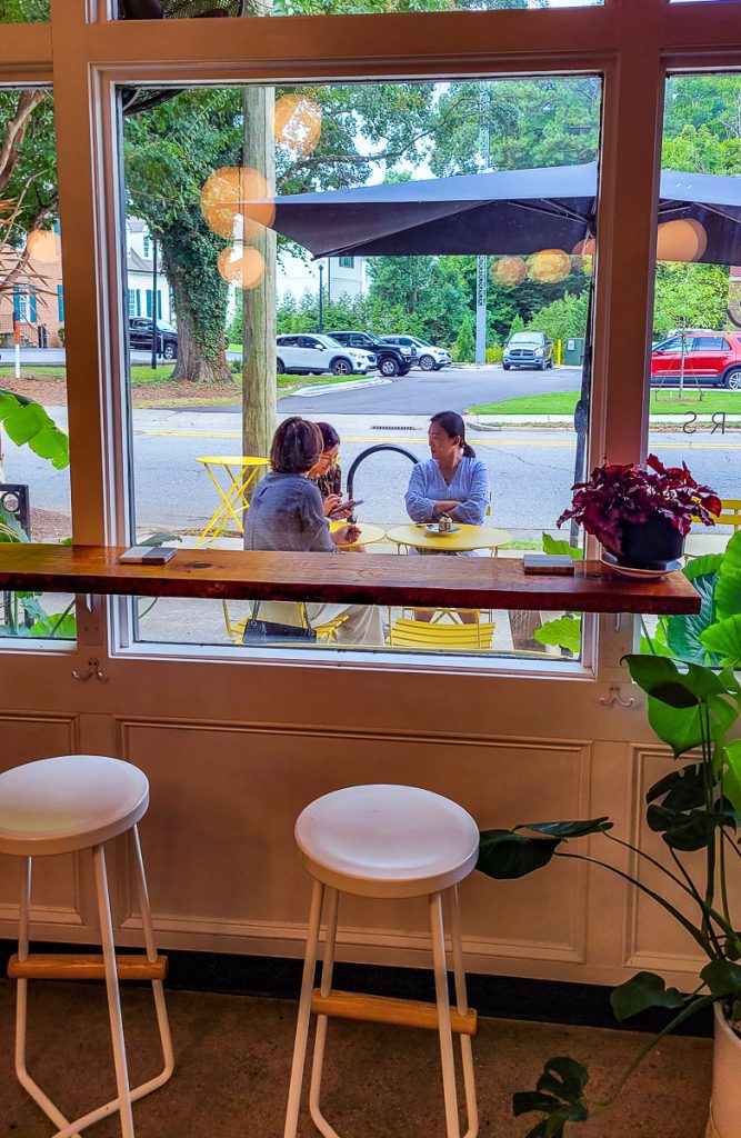 Two stolls, a window and people sitting outside - Idle Hour Coffee Shop, Raleigh