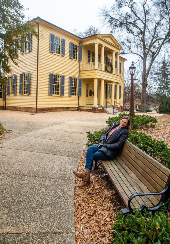Lady sitting in front of a historic home