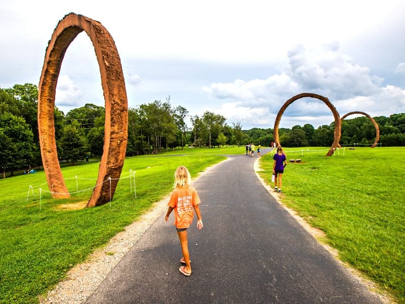 Girl walking towards a giant ring of art work