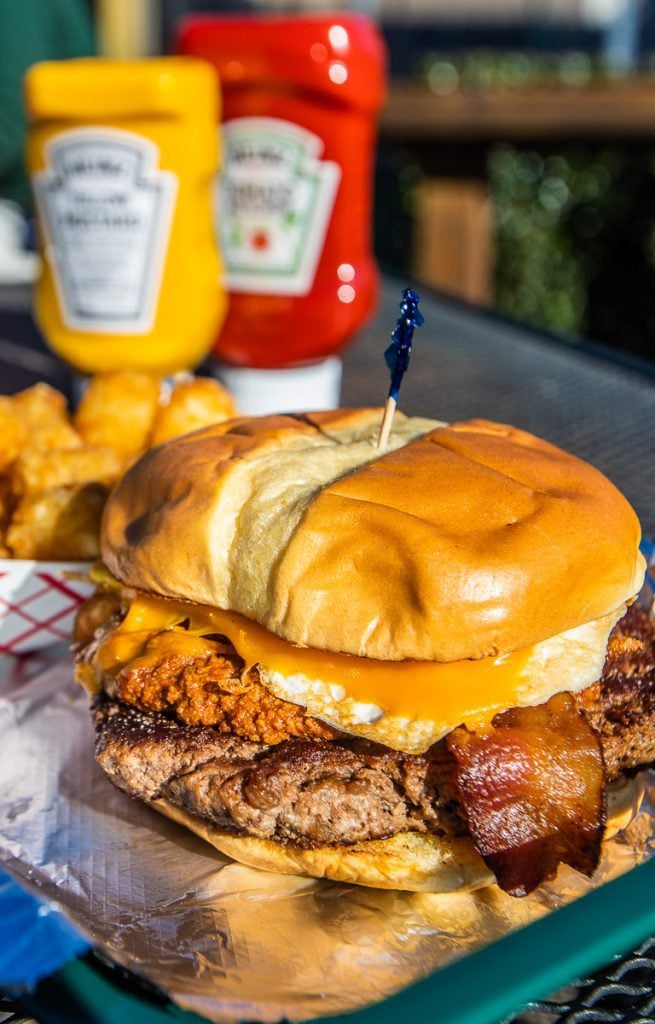 Hamburger with bacon and cheese and ketchup bottles