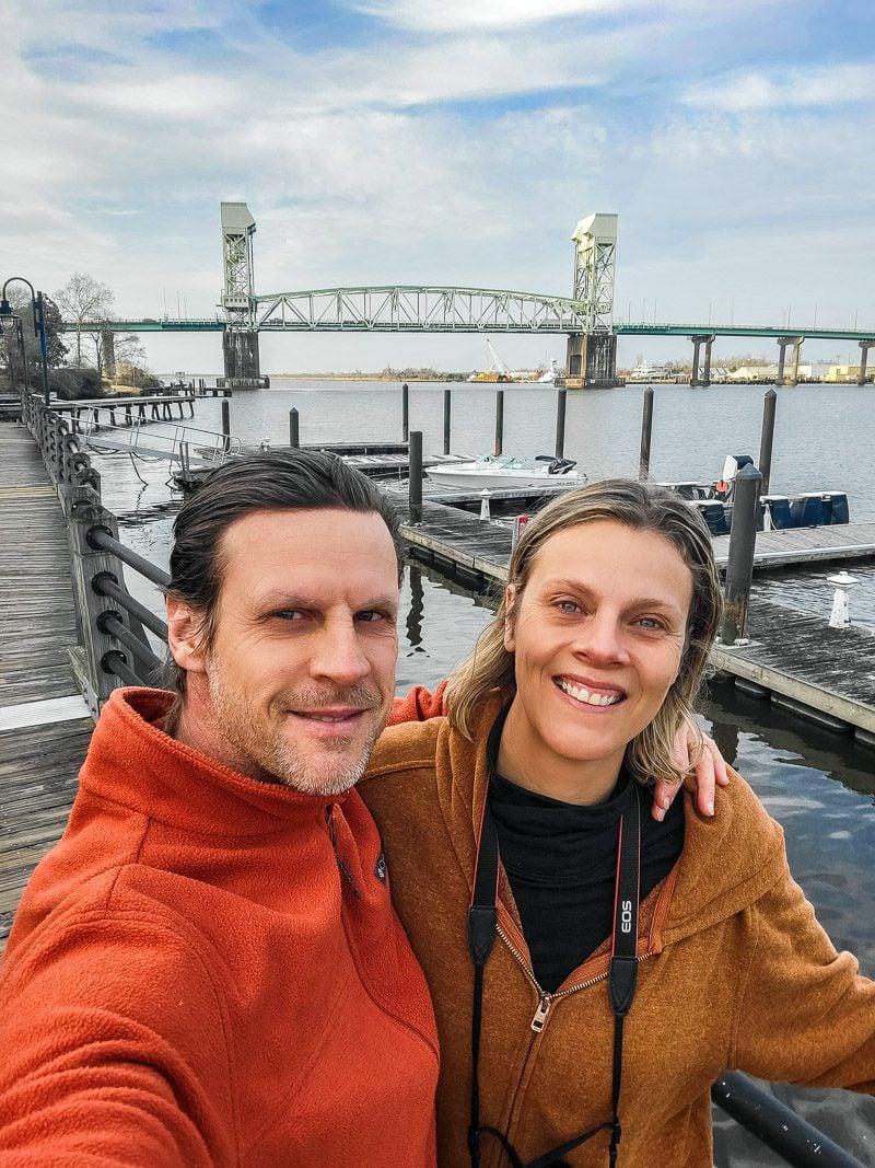 Couple taking a photo with a bridge in the background