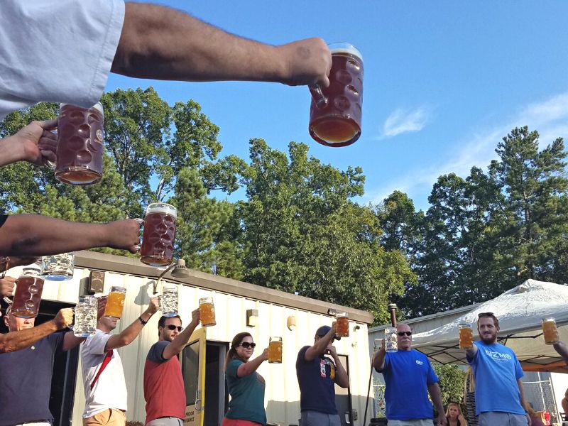 Group of men holding our jugs of beer at Oktoberfest