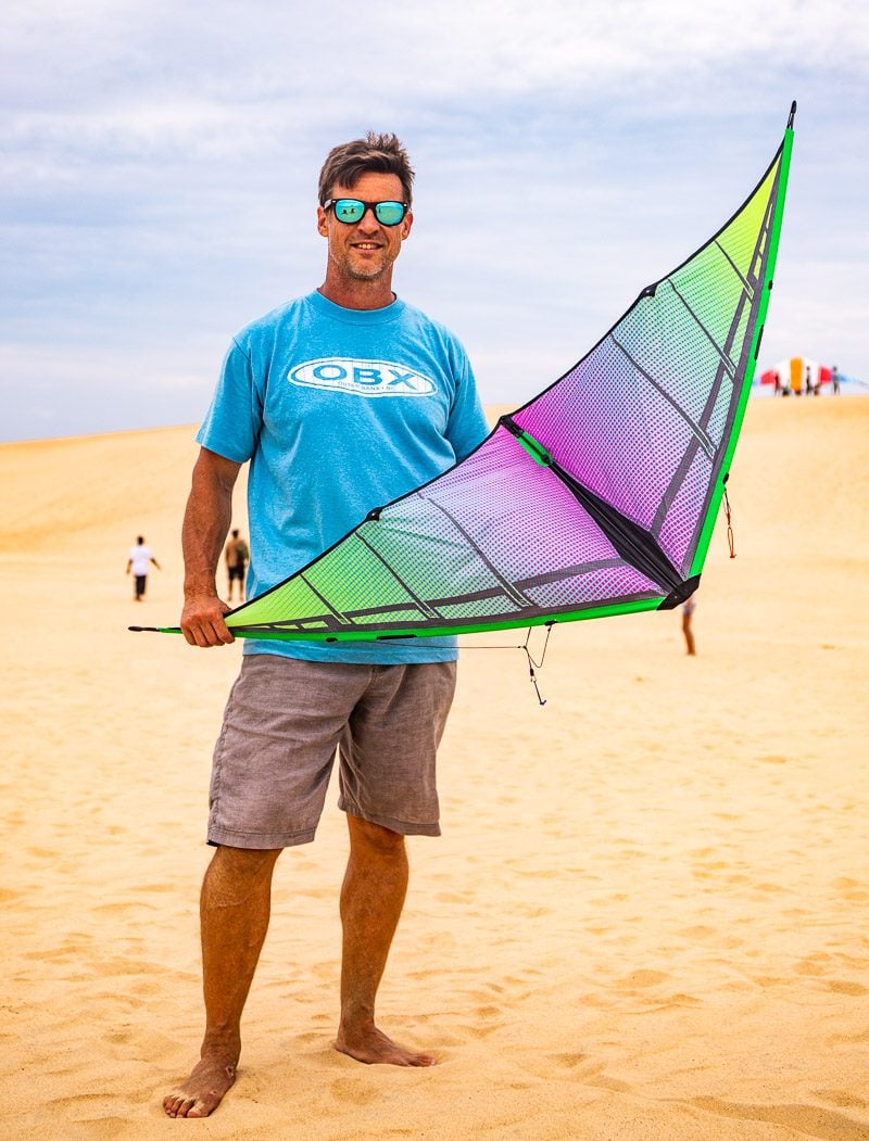 Man holding a kite in the sand dunes at Outer Banks
