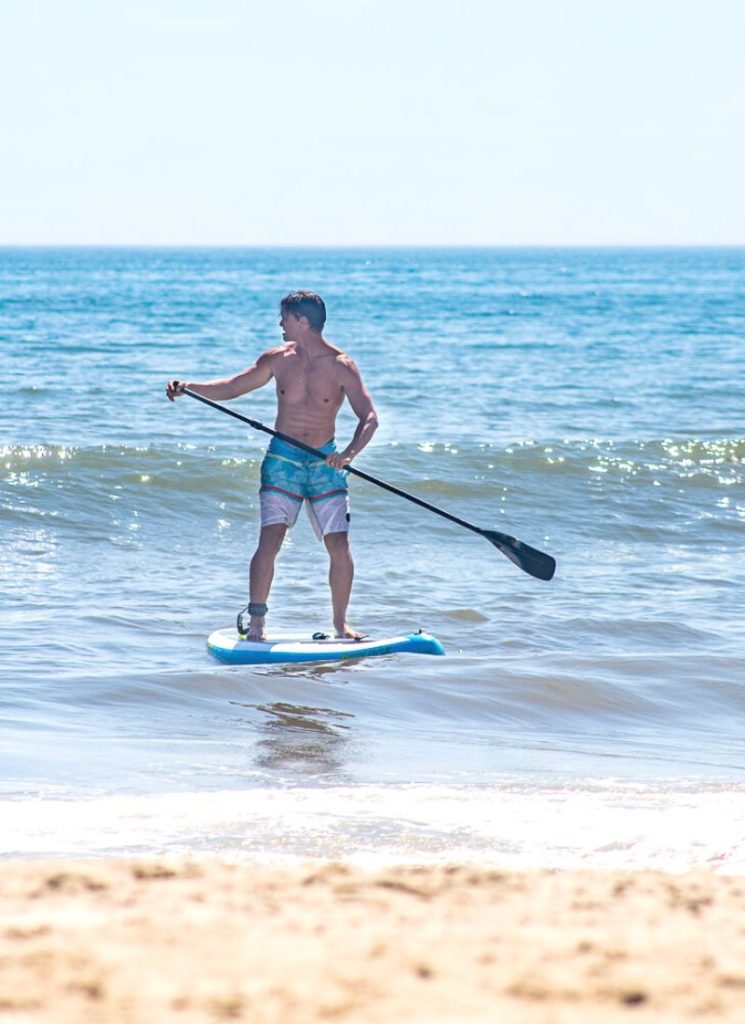 Man paddle boarding in the ocean at Outer Banks