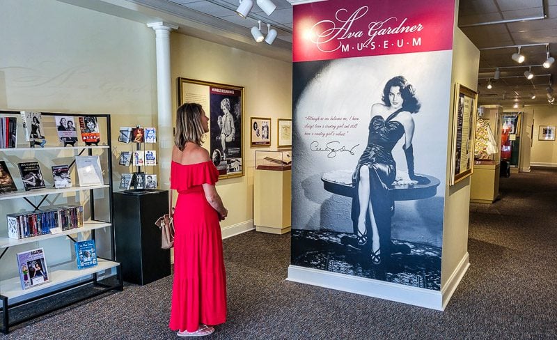 Woman admiring a poster of Ava Gardner in a museum