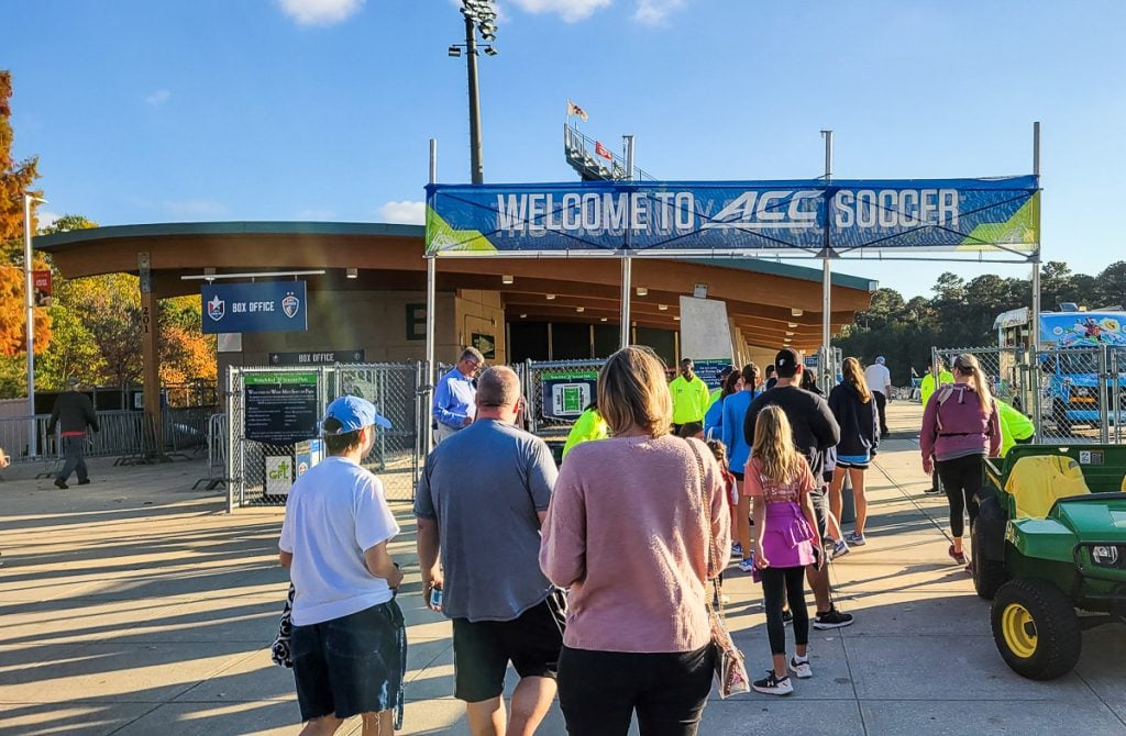 People lined up at the entrance of a soccer stadium