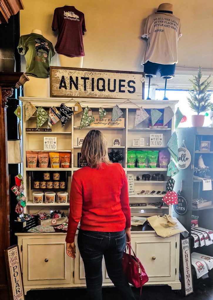Lady looking at antiques for sale in a store