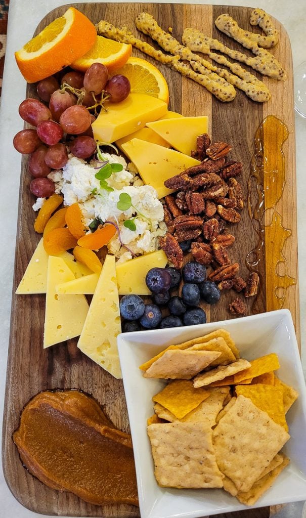 Charcuterie board of cheese, crackers, grapes, blueberries