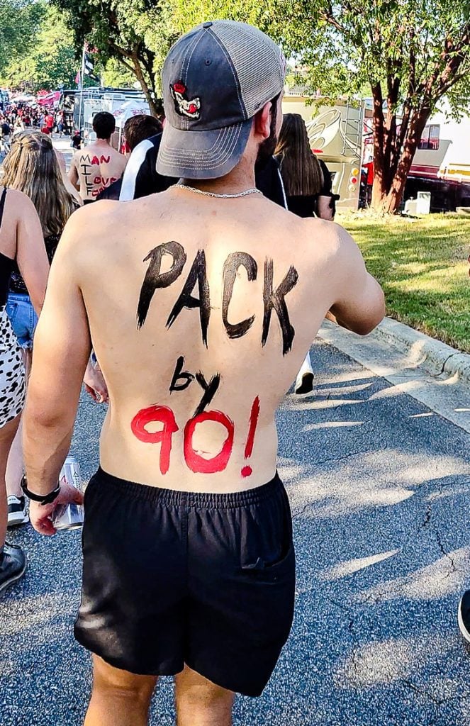 Man with his shirt off and the words Pack by 90 painted on his back