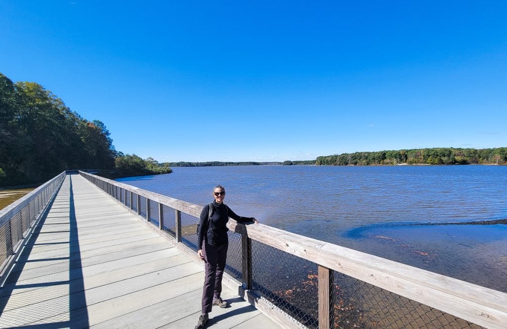 Woman walking across a bridge over a lake