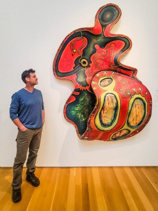 Man looking at a piece of artwork in a museum