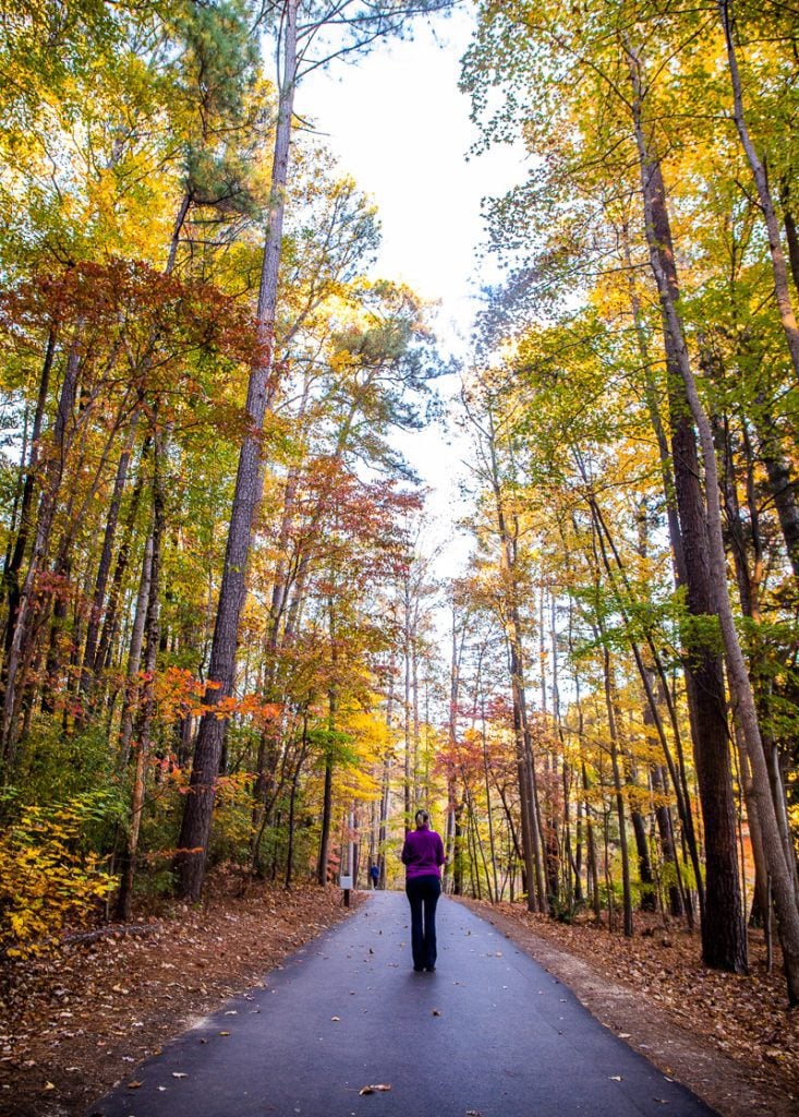 Woman walking a greenway trail in the Fall