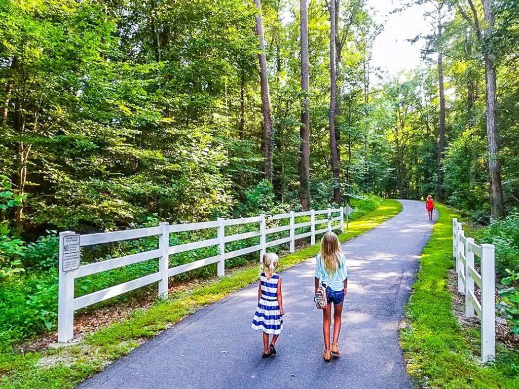 Two young girls walking along a greenway trail