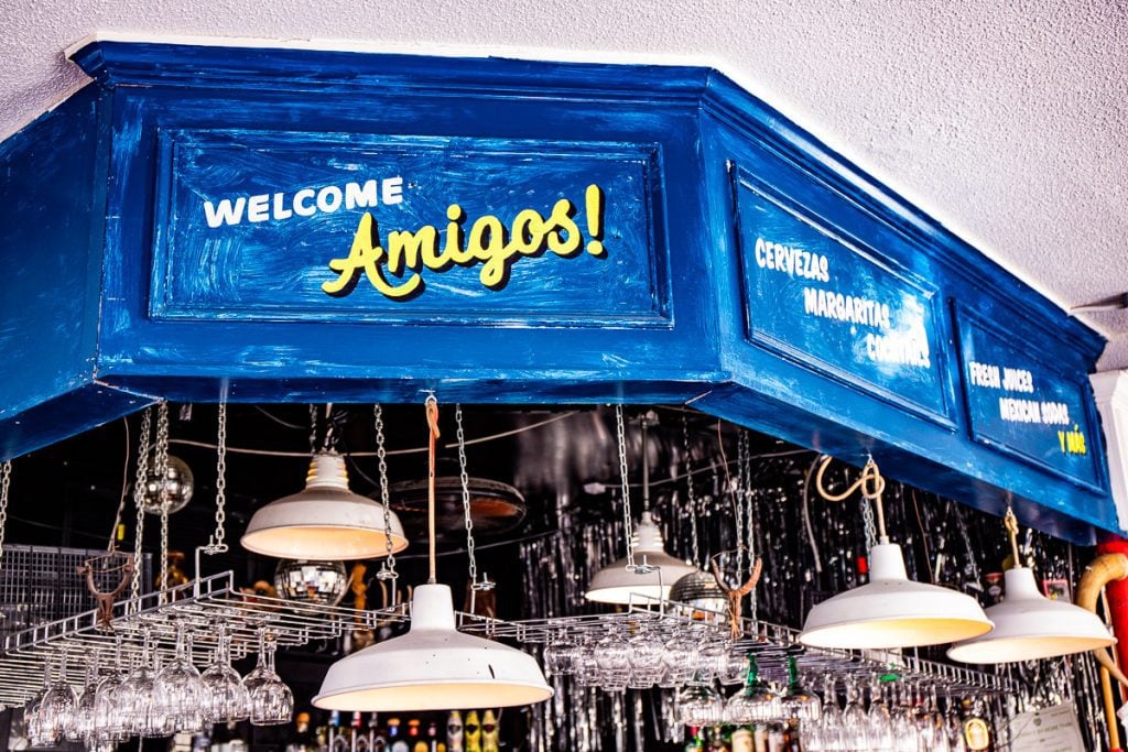 Bar in a restaurant with a sign saying "Welcome Amigos"