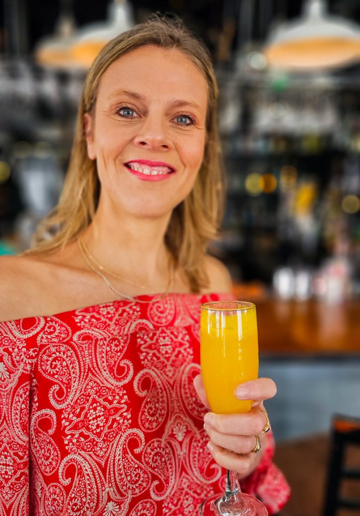 Lady holding a glass of Mimosa