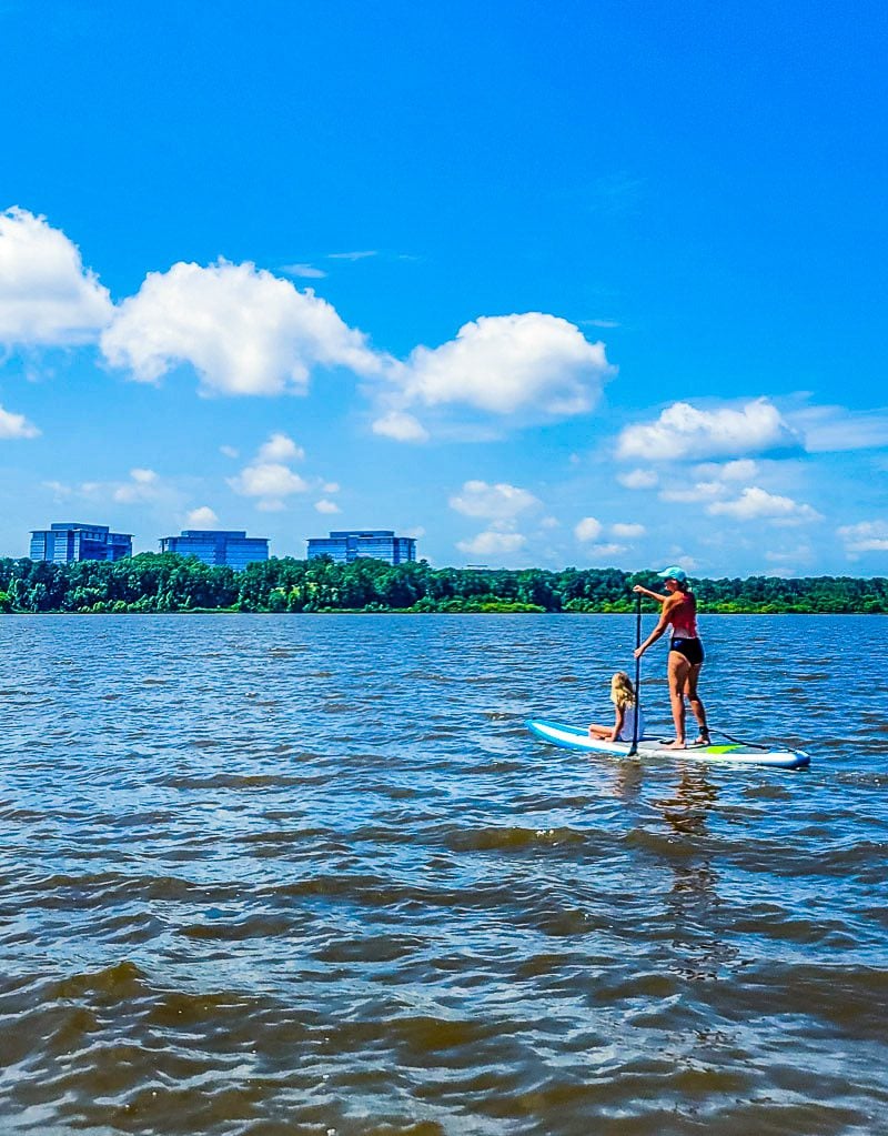 Mom and daughter on a stand up paddle board on a lake