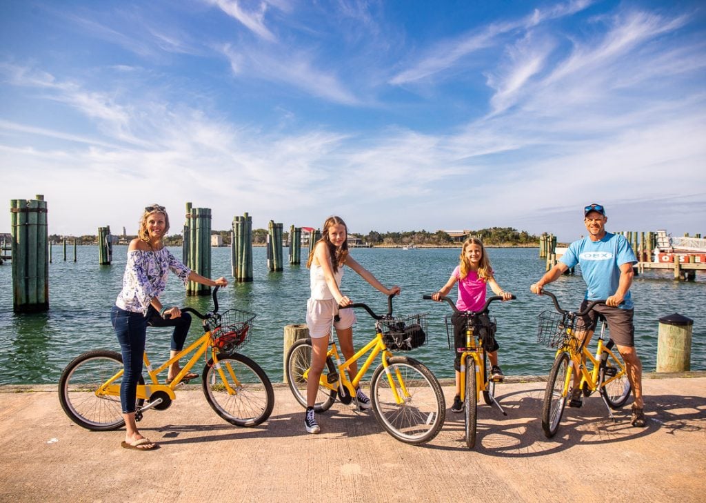 people on bikes by ocracoke marina posing to camera