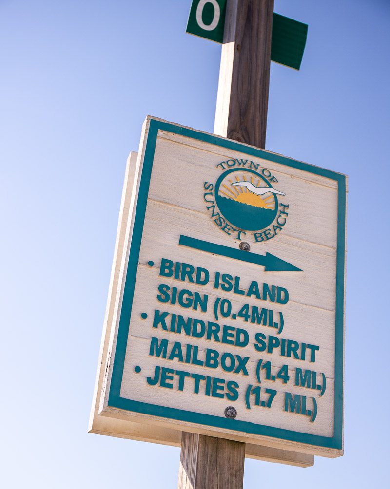 Sign on a beach showing direction
