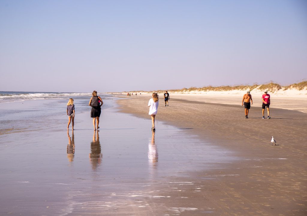Mom and daughters walking on a beach