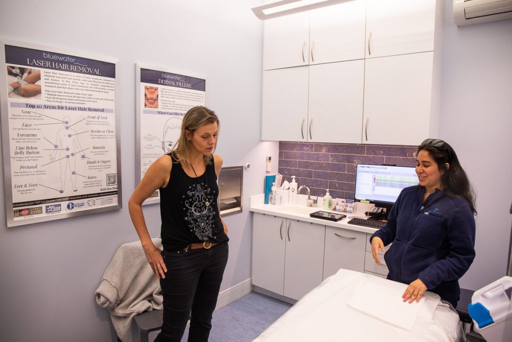 Two ladies standing in a clinic discussing laser hair removal treatment