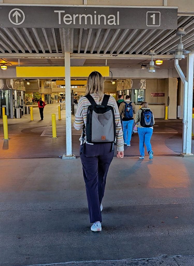 Lady walking into the entrance of an airport