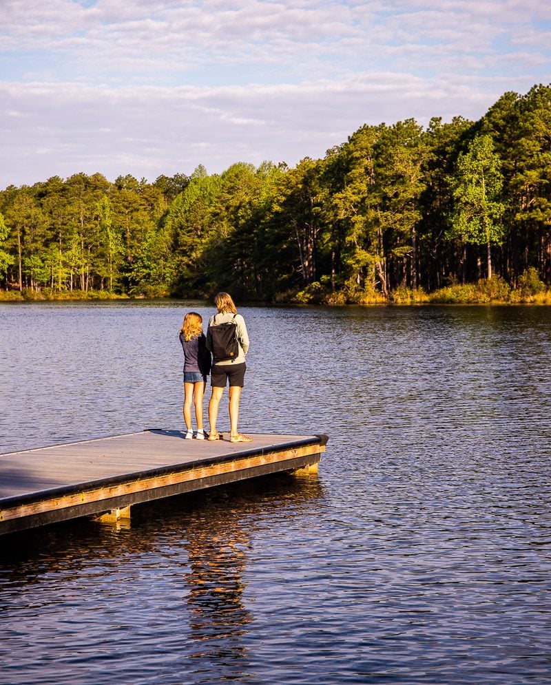 Mom and daughter standing on a jetty at a lake