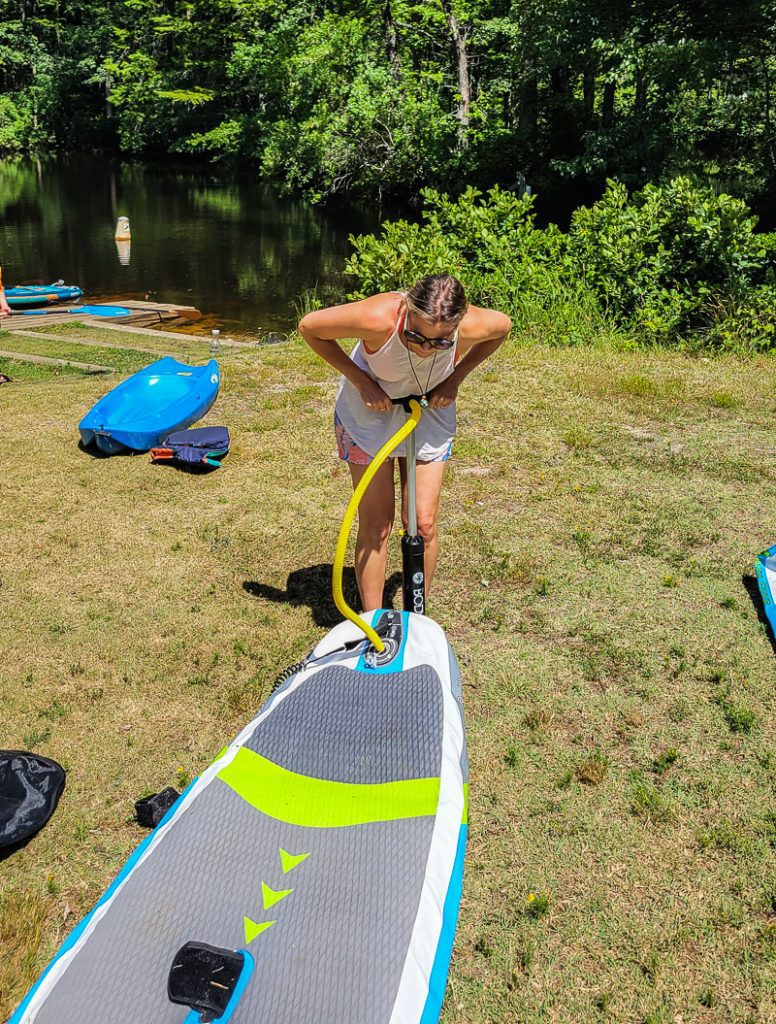 Woman pumping up a stand up paddle board