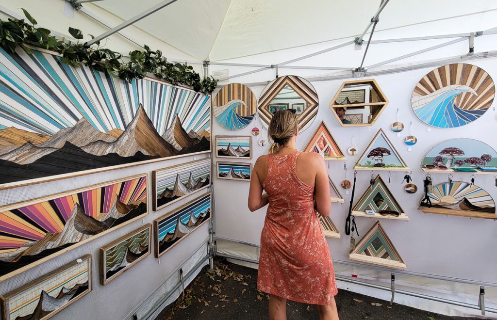 Lady looking at art displays inside a tent