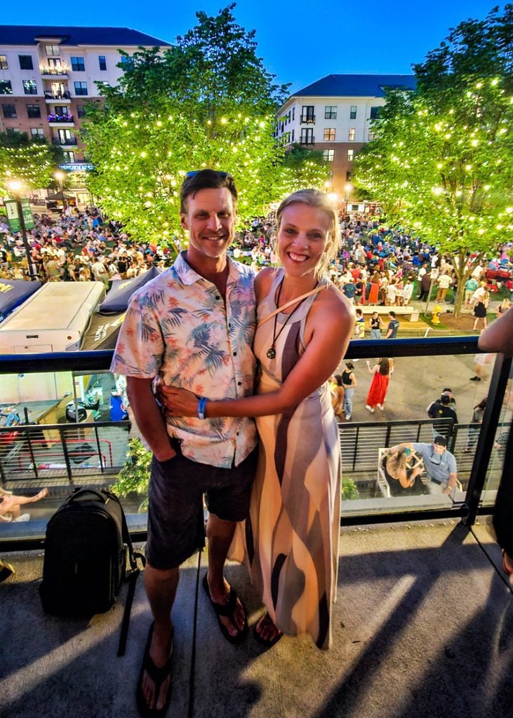 Couple standing on a deck at a festival hugging