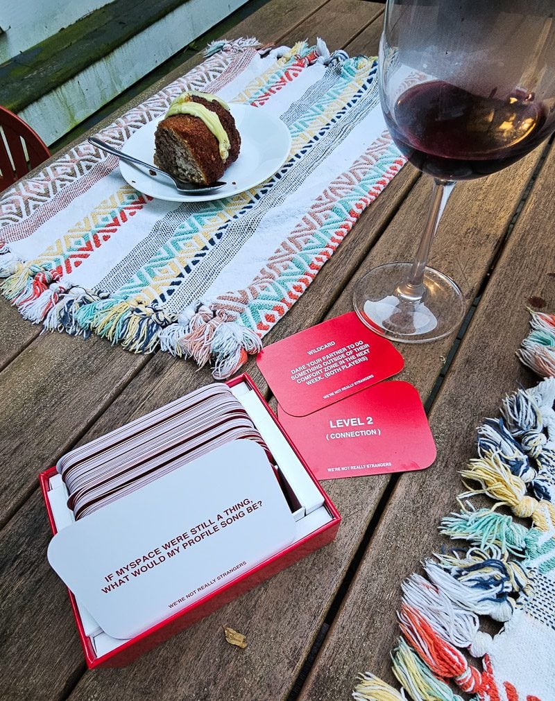 Packet of game cards on a table and glass of red wine
