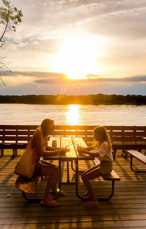 caroline and savannah playing cards at sunset by the lake