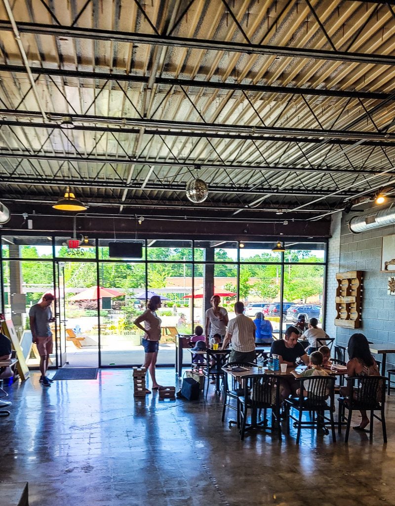 People sitting at tables inside a brewery