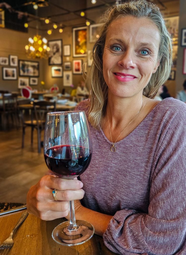 Carolina Makepeace holding a glass of red wine